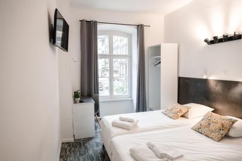 a bedroom with a bed with white sheets and a window at Hotel des Arts - Centre Cathédrale in Strasbourg