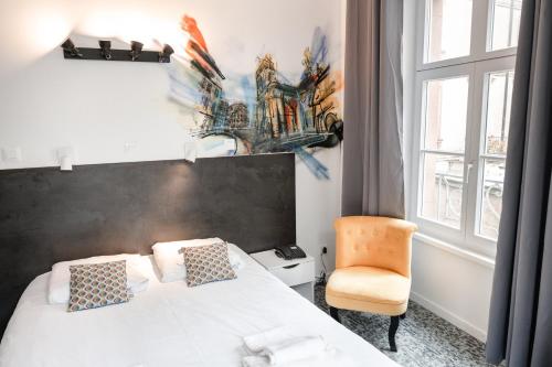 a bedroom with a bed and a chair and a window at Hotel des Arts - Centre Cathédrale in Strasbourg