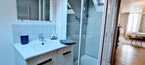 a bathroom with a sink and a shower at 3 Emplacement Parfait ! 150m de la mer et de la rue Piétonne in Dieppe