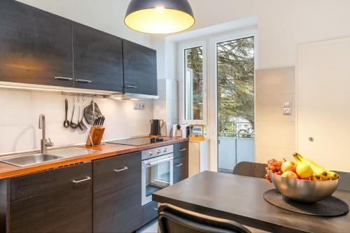 a kitchen with a table with a bowl of fruit on it at Modernes Apartment – 2 Boxspringbetten – Zentral in Kassel