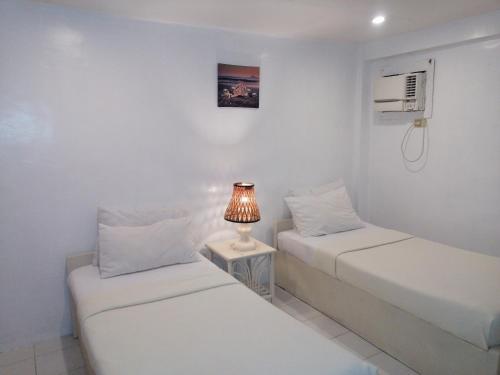 duas camas num quarto com um candeeiro sobre uma mesa em Seabird International Resort em Boracay