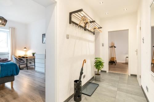 a living room with white walls and a hallway at Modernes Apartment – 2 Boxspringbetten – Zentral in Kassel