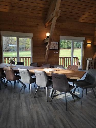 a dining room with a wooden table and chairs at La Ferme Du Levant in Gérardmer