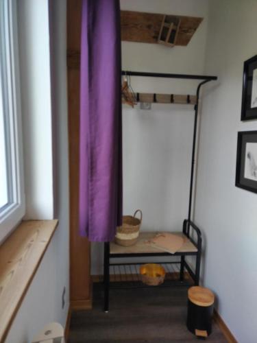 a room with a purple curtain and a table at La Ferme Du Levant in Gérardmer