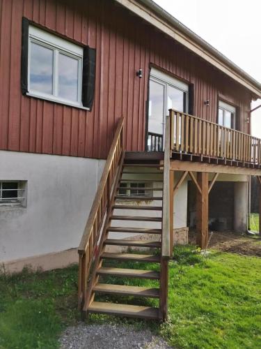 a house with a wooden staircase leading up to a house at La Ferme Du Levant in Gérardmer