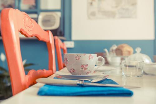 a table with a cup and a plate on a table at La Gare De Millas Chambres d'hôtes in Millas