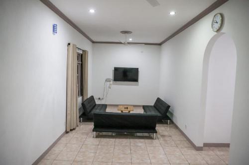 a room with a table and chairs and a tv at Riyaludhathuru Maldives in Thoddoo