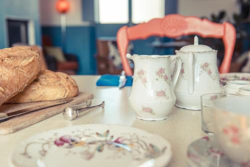 a table with two vases and a plate of bread at La Gare De Millas Chambres d'hôtes in Millas