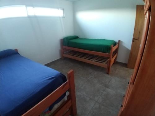 Zimmer mit 2 Betten und einem grünen Stuhl in der Unterkunft Complejo Betesda 1 in Federación