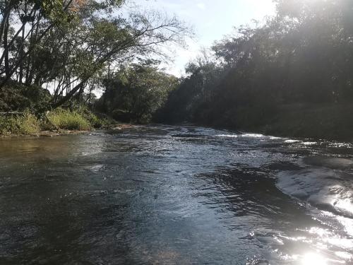 a river with trees on the side of it at El Paraje Camping in Piribebuy