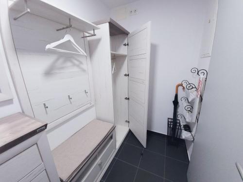 a walk in closet with white cabinets and a bench at Apartma M&J in Mojstrana