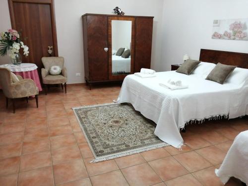 a bedroom with a bed and a table and a mirror at Villa Etna Masi' in Milo
