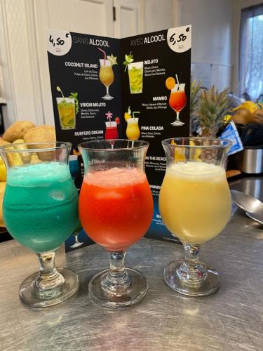 three different colored drinks in wine glasses on a counter at Logis Hôtel Le Clement V in Roquemaure