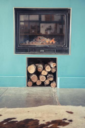 a pile of logs in a fire place at La Gare De Millas Chambres d'hôtes in Millas