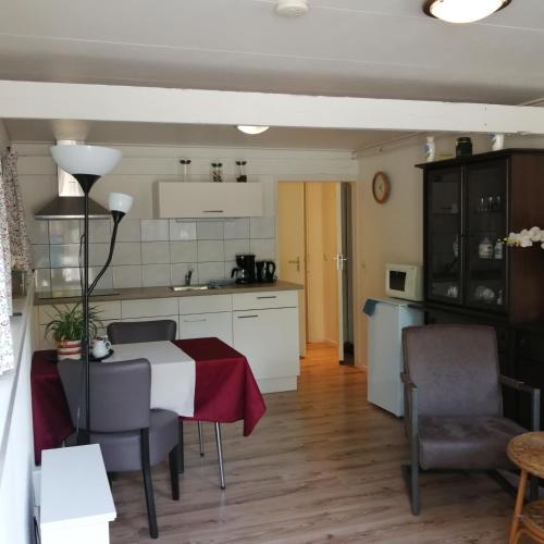 a kitchen and living room with a table and chairs at Veenemaat in Winterswijk