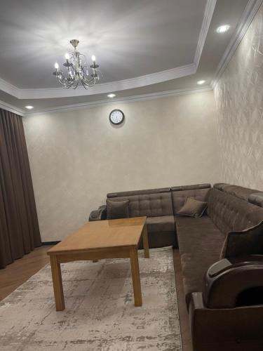 a living room with a couch and a table at Роща 7 in Bishkek