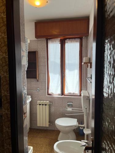 a small bathroom with a toilet and a sink at VillaMarinaPigra Lake View Apartments in Pigra