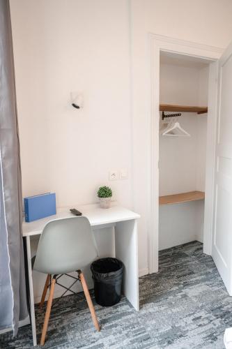 a desk and a chair in a room with a closet at Hotel des Arts - Centre Cathédrale in Strasbourg