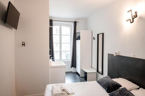 a bedroom with a bed and a sink and a mirror at Hotel des Arts - Centre Cathédrale in Strasbourg