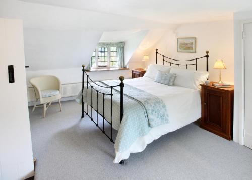 ein Schlafzimmer mit großem Bett und Fenster in der Unterkunft Letterbox Cottage in Chipping Campden