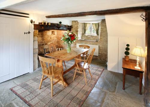 ein Esszimmer mit einem Holztisch und Stühlen in der Unterkunft Letterbox Cottage in Chipping Campden