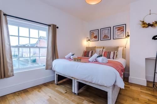 1 dormitorio con cama y ventana grande en Lovely 2-bed house in Chester by 53 Degrees Property, Ideal for Couples & Small Groups, Amazing Location - Sleeps 4 en Hough Green