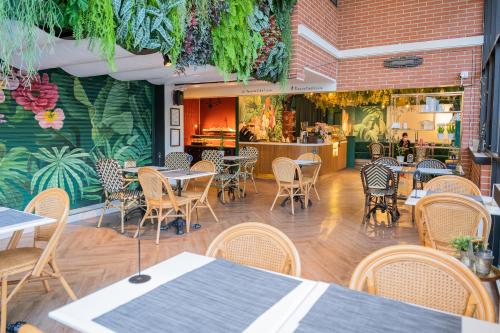 un ristorante con tavoli e sedie e un bar di The Riche Boutique Hotel Don Mueang Airport a Bangkok