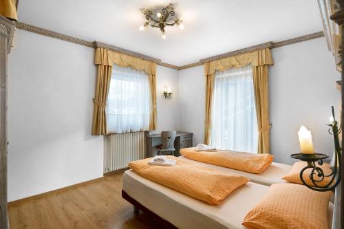 2 Betten in einem Zimmer mit 2 Fenstern in der Unterkunft Casa Li Roina n 43 in Livigno