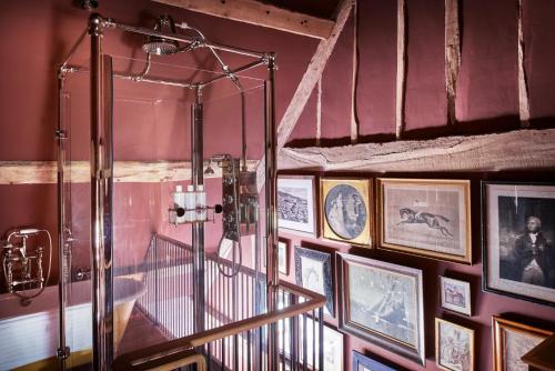 a shower in a room with pictures on the wall at St Giles House Accommodation in Wimborne Saint Giles