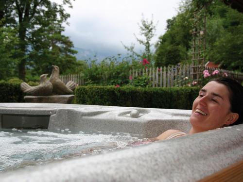 a woman in a hot tub in a yard at Landhaus Benediktenhof in Bad Tölz