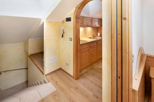 een kleine keuken met houten kasten en een hal bij Casa Li Roina n 44 in Livigno