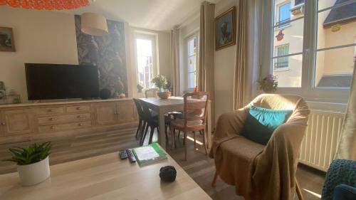 salon ze stołem i telewizorem w obiekcie 23 Lesigne w mieście Lisieux