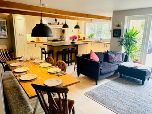 a dining room and living room with a table and chairs at Idyllic Country Cottage near Soho, Oxford & Cotswolds in Banbury