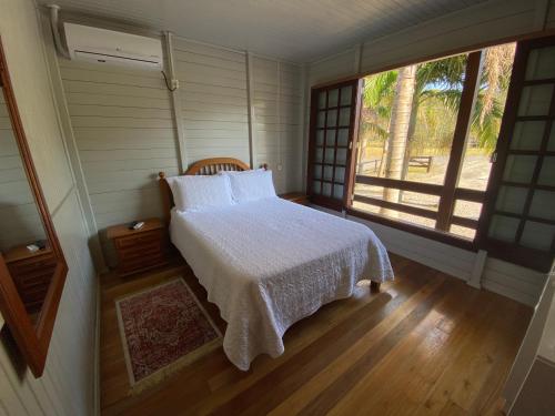 een slaapkamer met een wit bed en een raam bij Pousada Costão da Serra in Lauro Müller