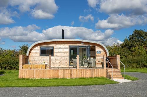 a small circular house with a wooden deck at High Longlands in Cartmel