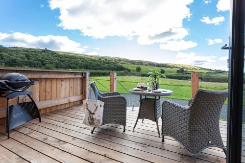 a patio with a table and chairs on a deck at High Longlands in Cartmel