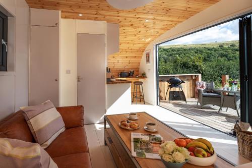 a living room with a table with a bowl of fruit at Little Heaning in Cartmel