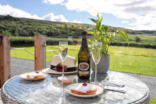 a table with a bottle of wine and plates of food at High Longlands in Cartmel