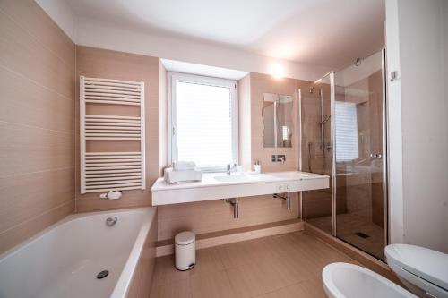 a bathroom with a tub and a sink and a toilet at Ferienhaus - Das Goldgassl in Appiano sulla Strada del Vino