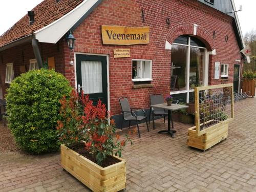 a red brick building with a table and chairs outside at Veenemaat in Winterswijk