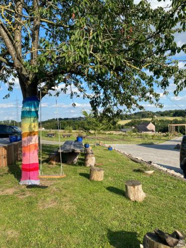 a rainbow colored tree with a swing in a park at Little Farm Comfort&PrestigeHouse in Ittre