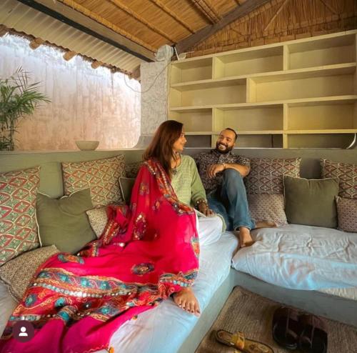 un hombre y una mujer sentados en un sofá en Mandawa Kothi en Mandāwa