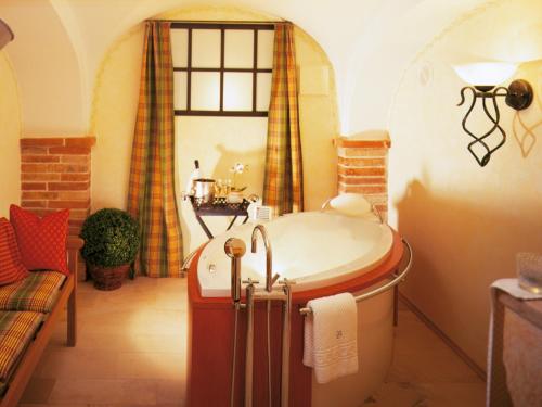 a bathroom with a tub and a window at Landhaus Benediktenhof in Bad Tölz