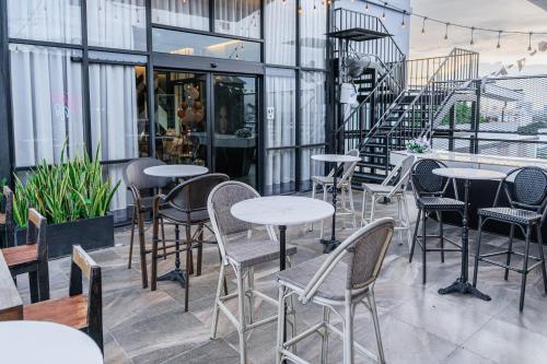 a row of tables and chairs on a patio at The Riche Boutique Hotel Don Mueang Airport in Bangkok