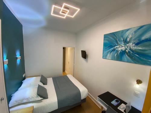 a bedroom with a bed and a painting on the wall at Lyo Hôtel - Centre Lyon Perrache in Lyon