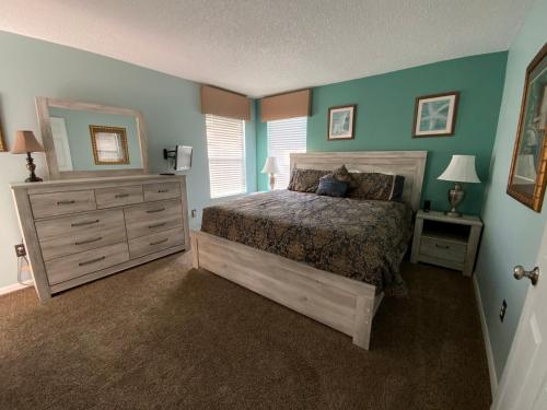 Schlafzimmer mit einem Bett, einer Kommode und einem Spiegel in der Unterkunft Seasons Villa 6 bedrooms, 4 masters and water view in Kissimmee