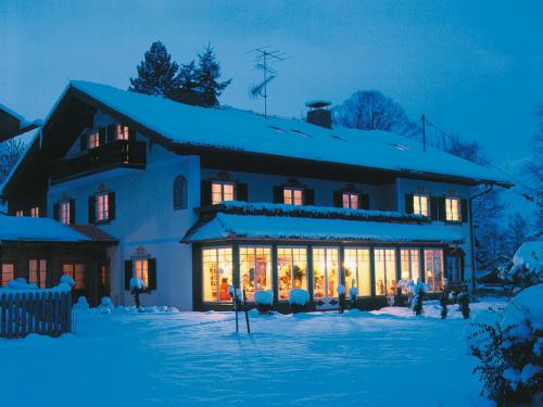 a house covered in christmas lights in the snow at Landhaus Benediktenhof in Bad Tölz