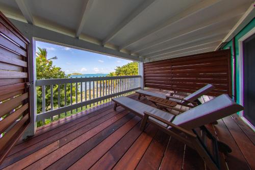 a large wooden deck with two benches on it at Tamarind Reef Resort Spa & Marina in Christiansted