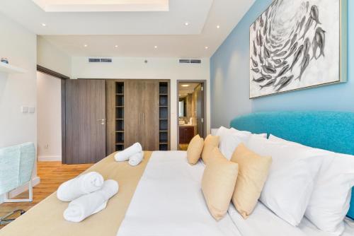 um quarto com uma cama grande e almofadas brancas em Lofts · Downtown Luxury · 5 Min Walk To Dubai Fountain! em Dubai