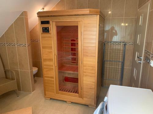 a wooden cabinet in a bathroom with a toilet at Apartmány City 2 in Ostrava